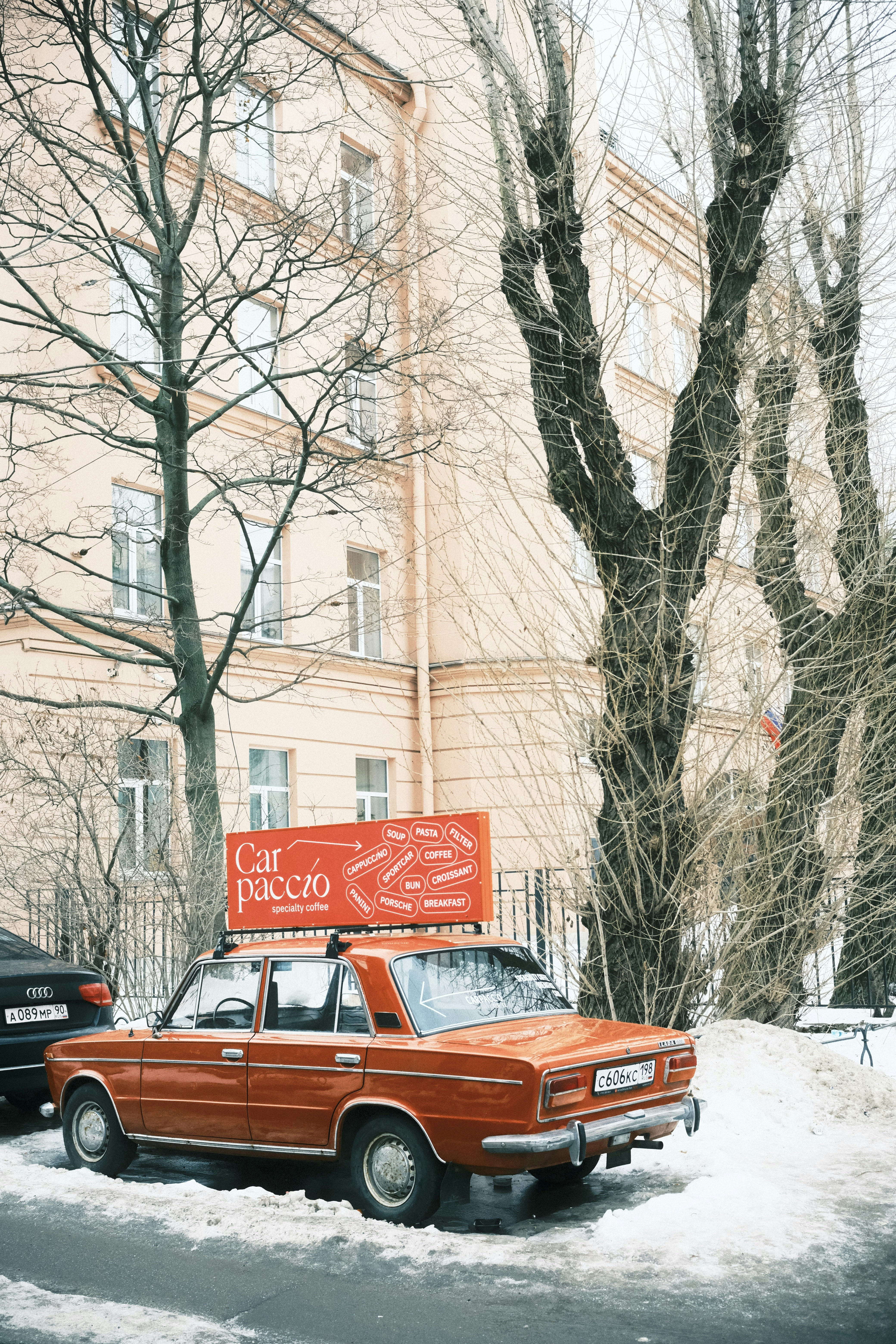 Un coche rojo aparcado frente a un edificio alto
