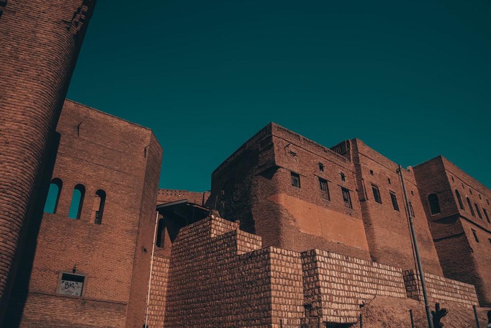 a tall brick building with a clock on it's side