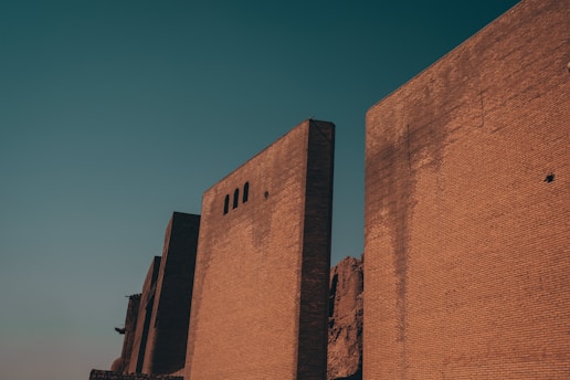 a tall brick building with a clock on the side of it