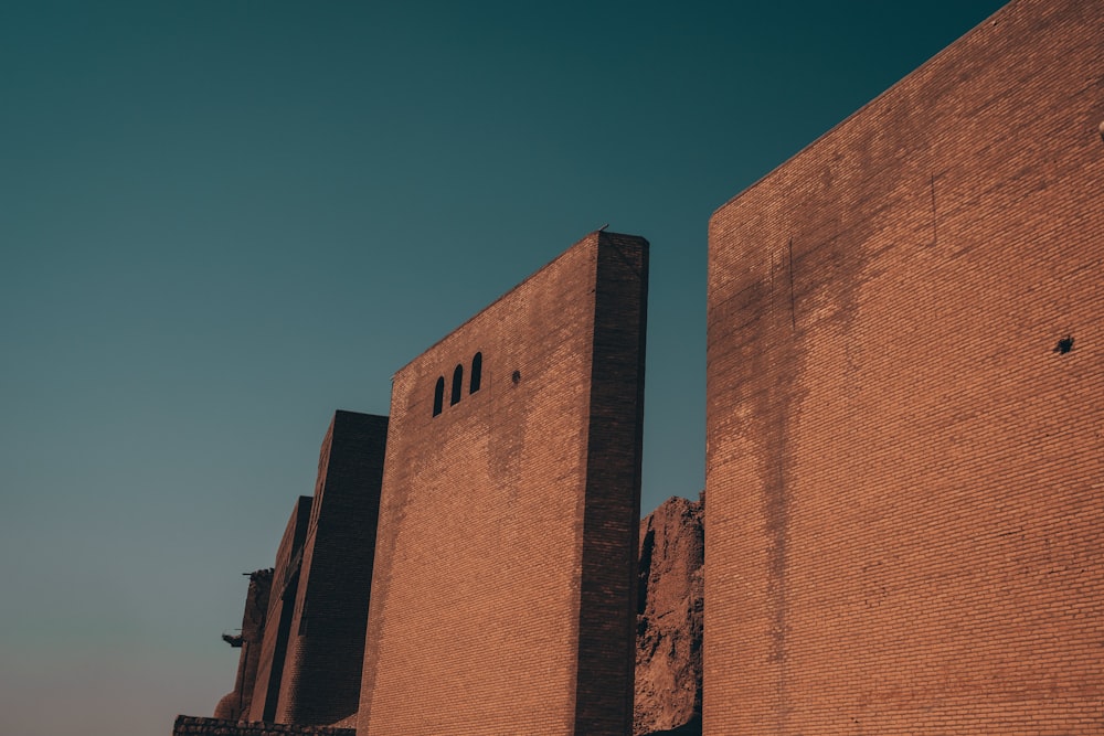 a tall brick building with a clock on the side of it