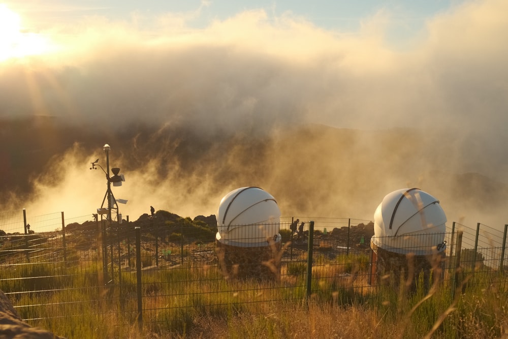 a couple of white domes sitting on top of a lush green field