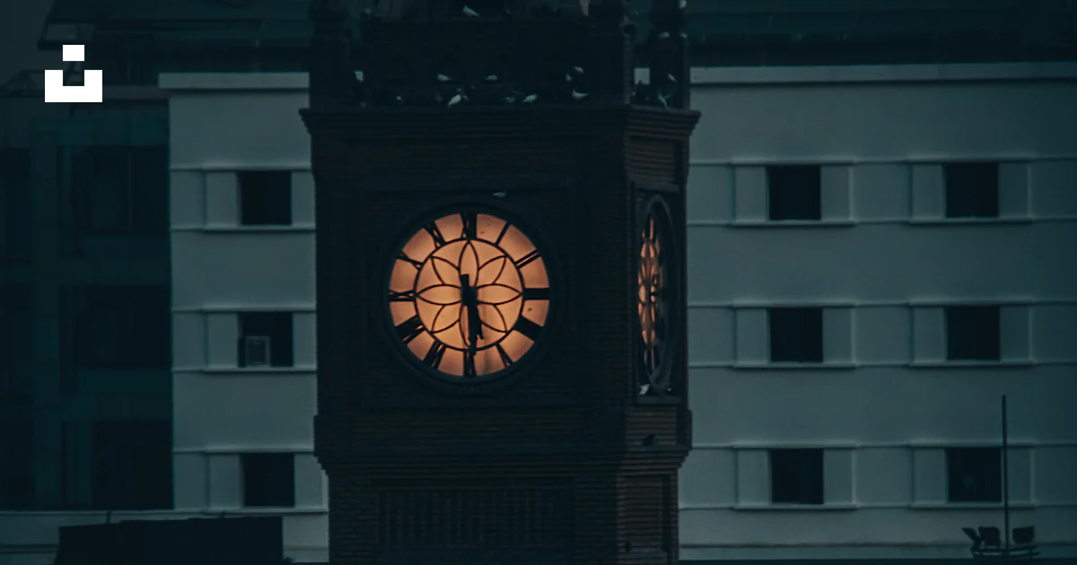 Iraq Clock A clock tower lit up in the dark photo – Free Iraq Image on Unsplash
