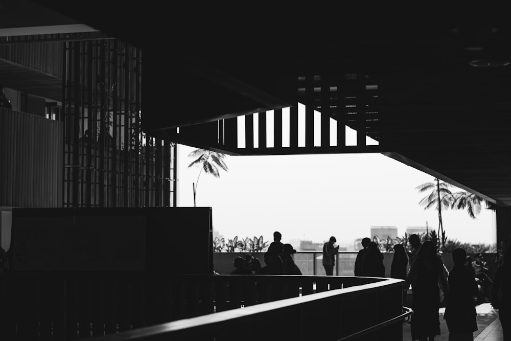 a black and white photo of people walking down a walkway