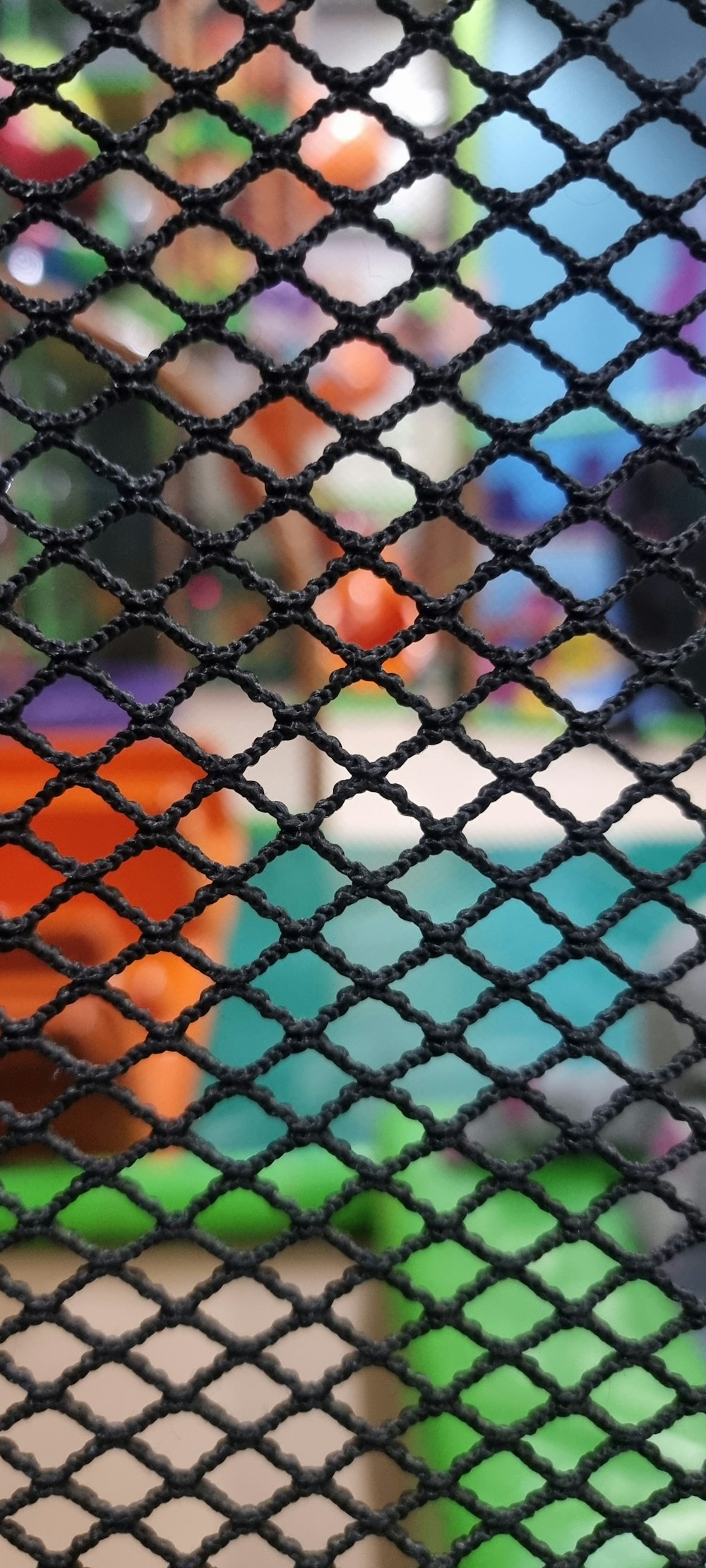a close up of a net with a colorful object in the background