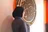a person in a hijab standing in front of a sign