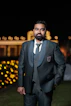 a man in a tuxedo poses for a picture
