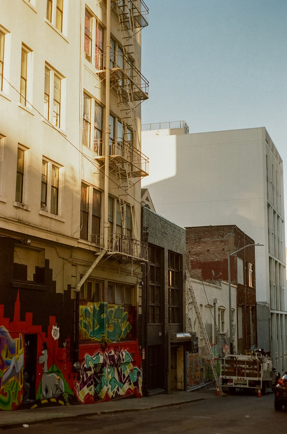 a city street with graffiti on the side of buildings