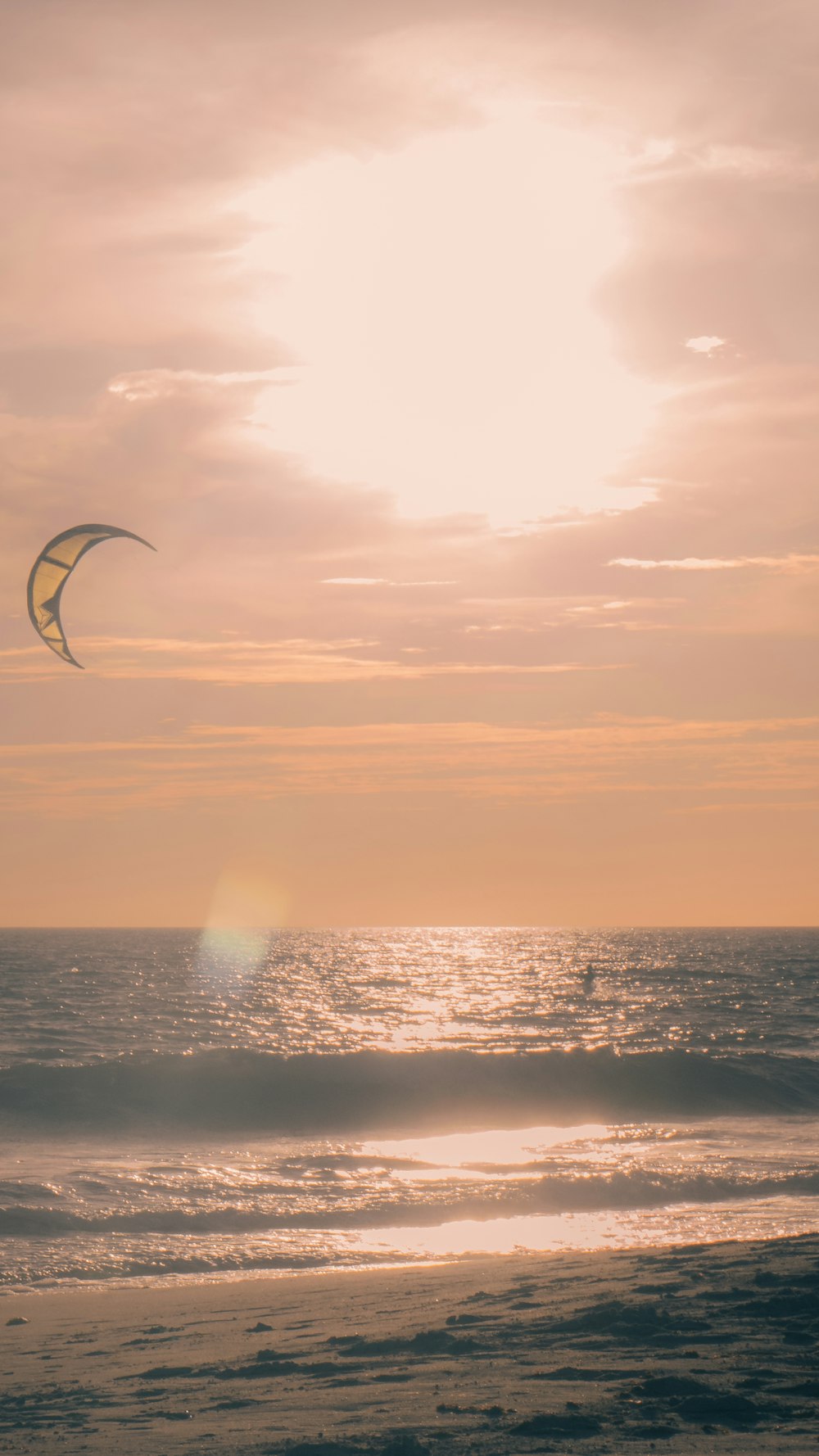 a person on the beach flying a kite