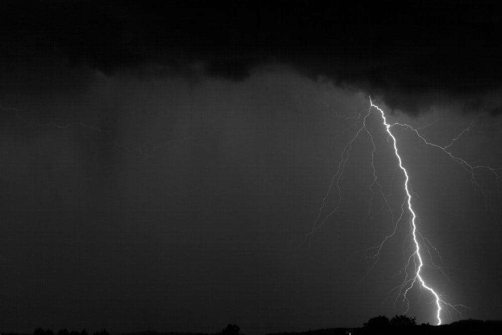 a black and white photo of a lightning storm