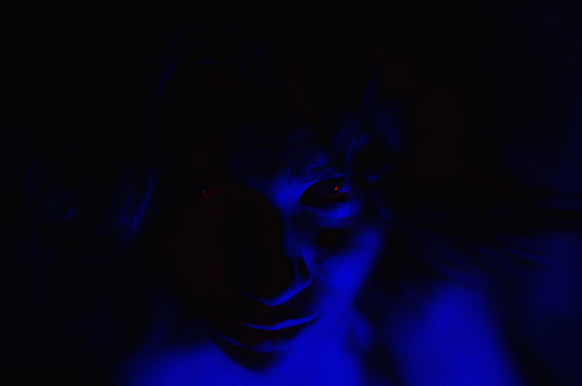 a woman with red eyes in a dark room