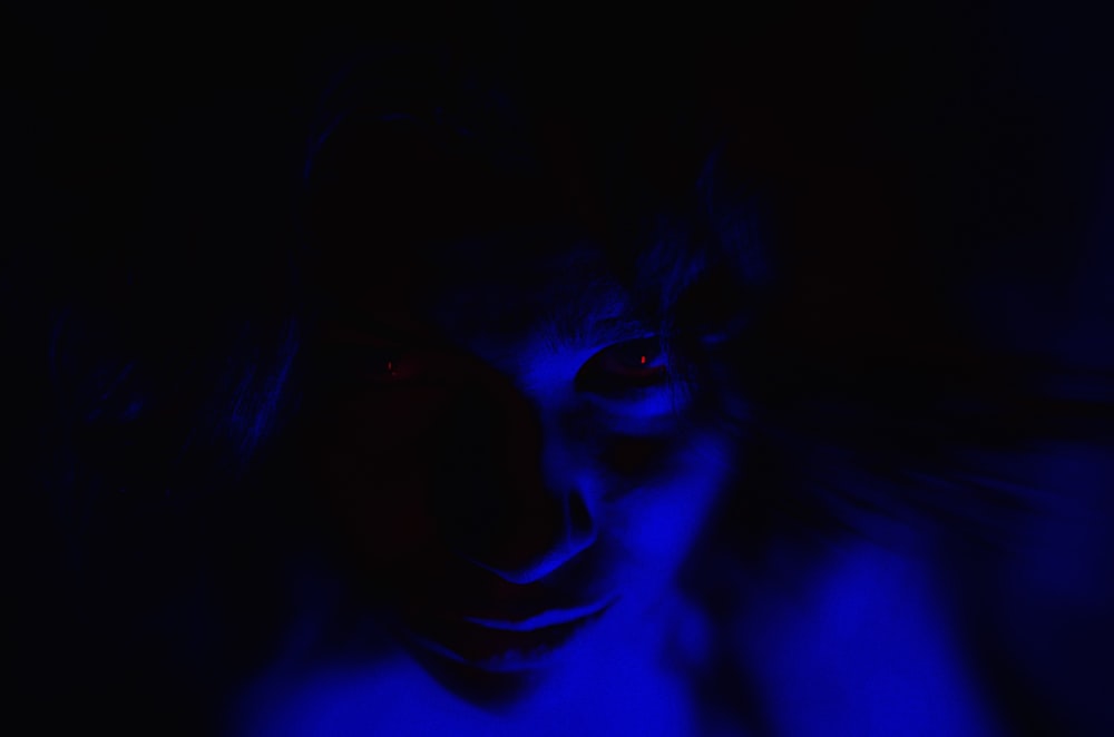 a woman with red eyes in a dark room