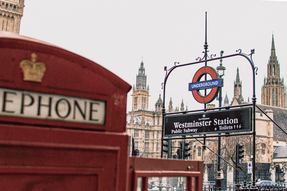 a red phone booth sitting in front of a tall building