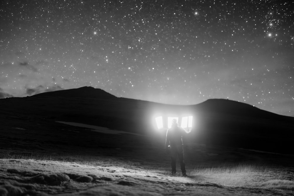 a person standing in the snow under a night sky