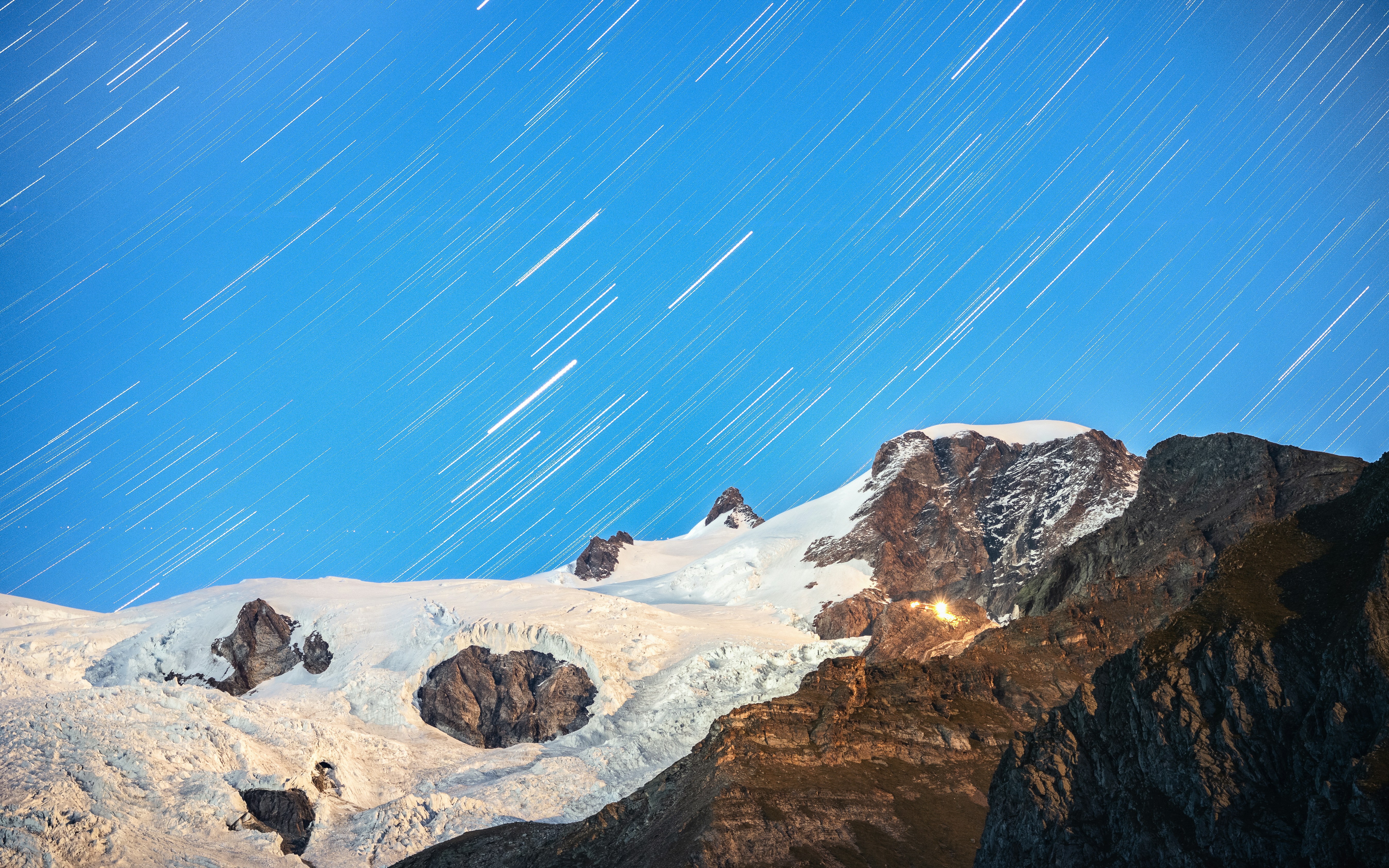 a snow covered mountain with stars in the sky