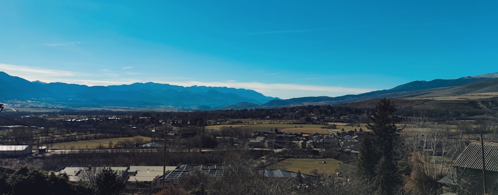 Una vista de una ciudad y las montañas desde una colina