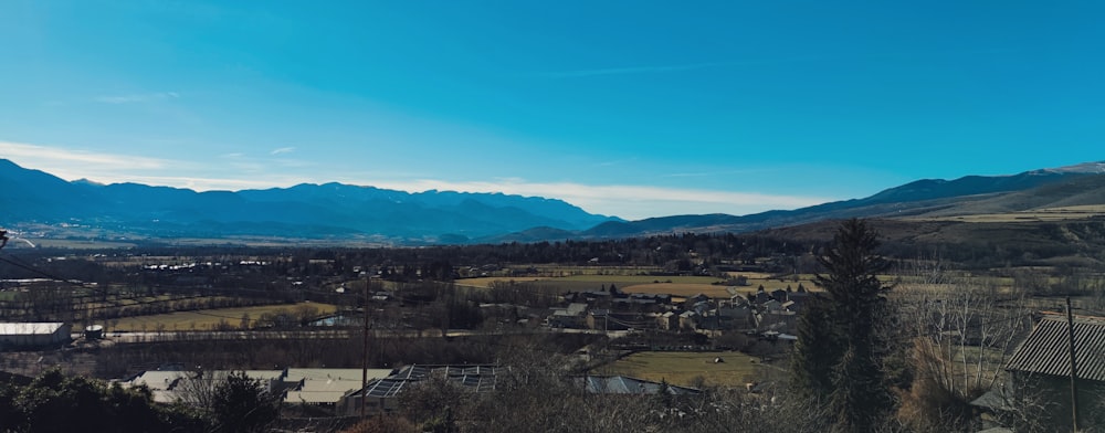 a view of a town and mountains from a hill