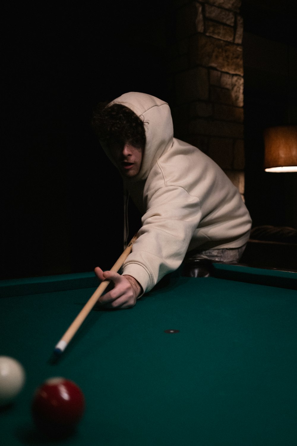 a man leaning over a pool table with a cue in his hand
