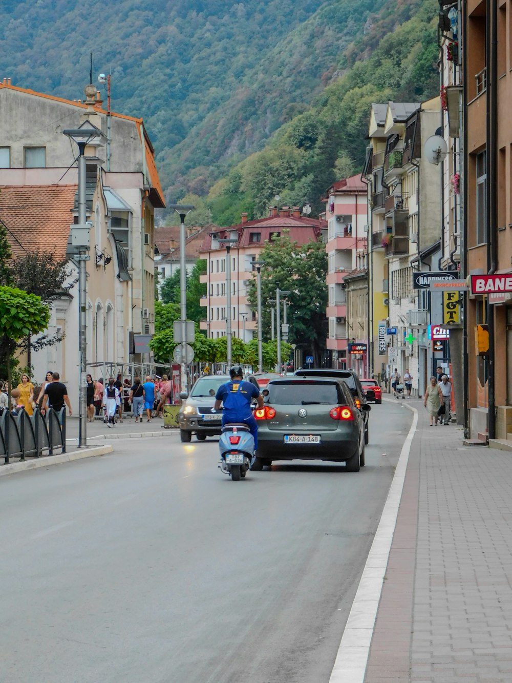 a motorcyclist riding down a street in a town