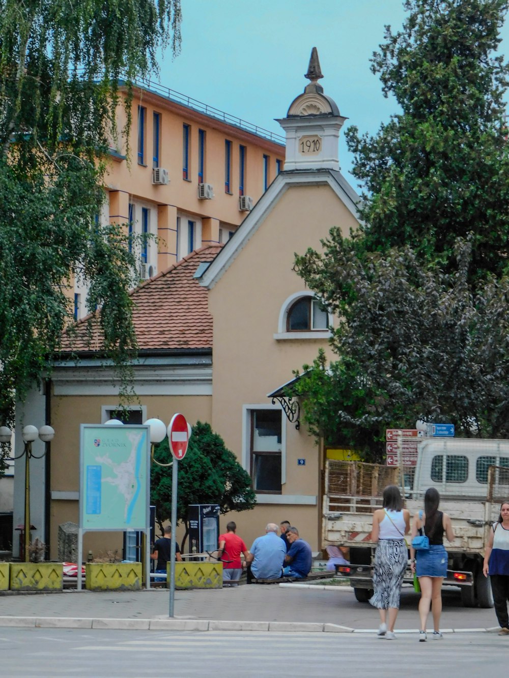 a group of people walking down a street next to a building