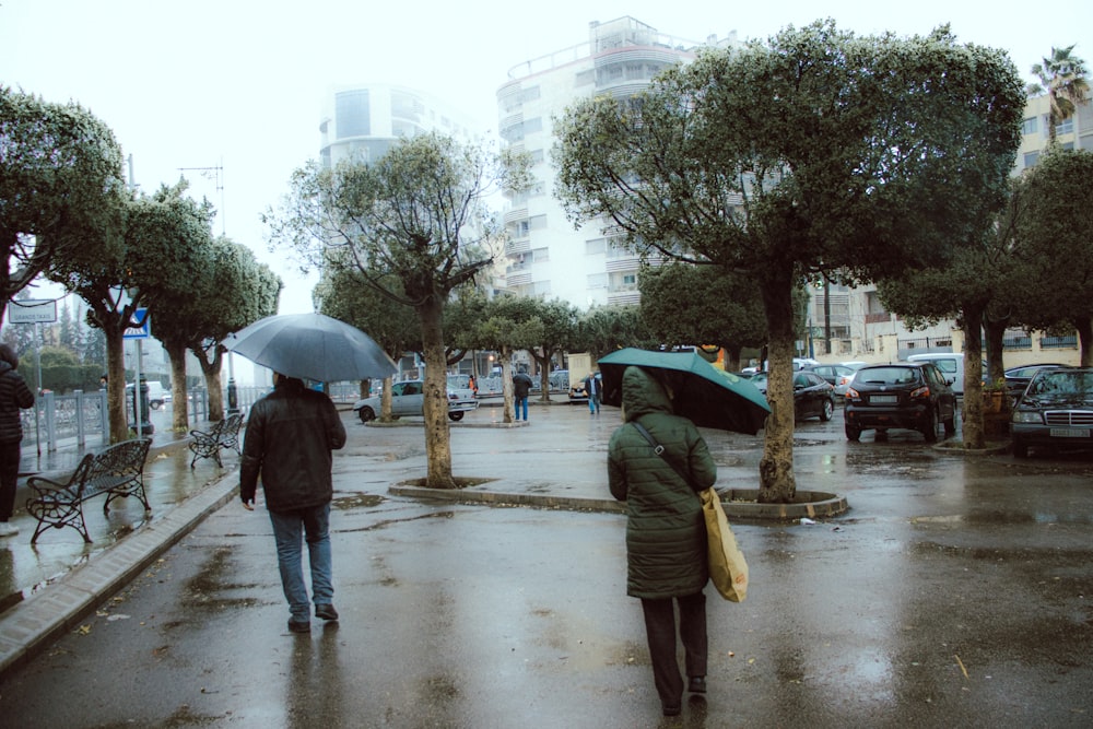 two people walking in the rain with umbrellas