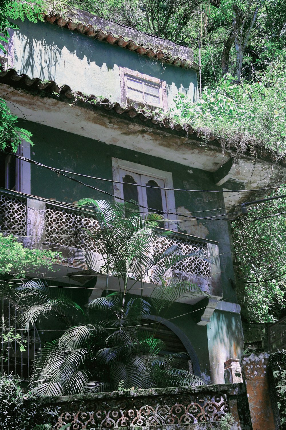 a building with a balcony and a tree in front of it