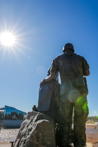 a statue of a man standing next to a rock