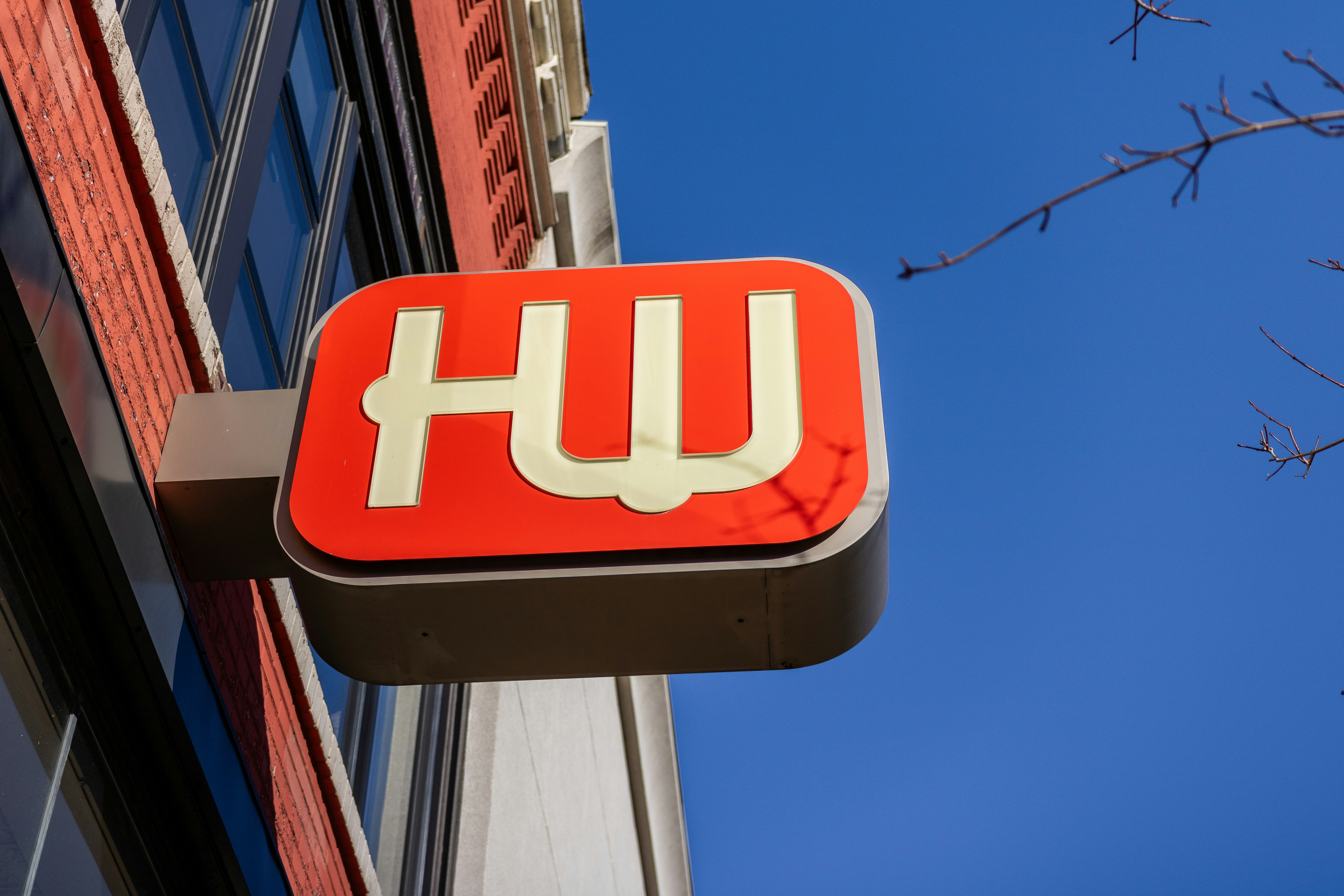 a red and white sign hanging from the side of a building
