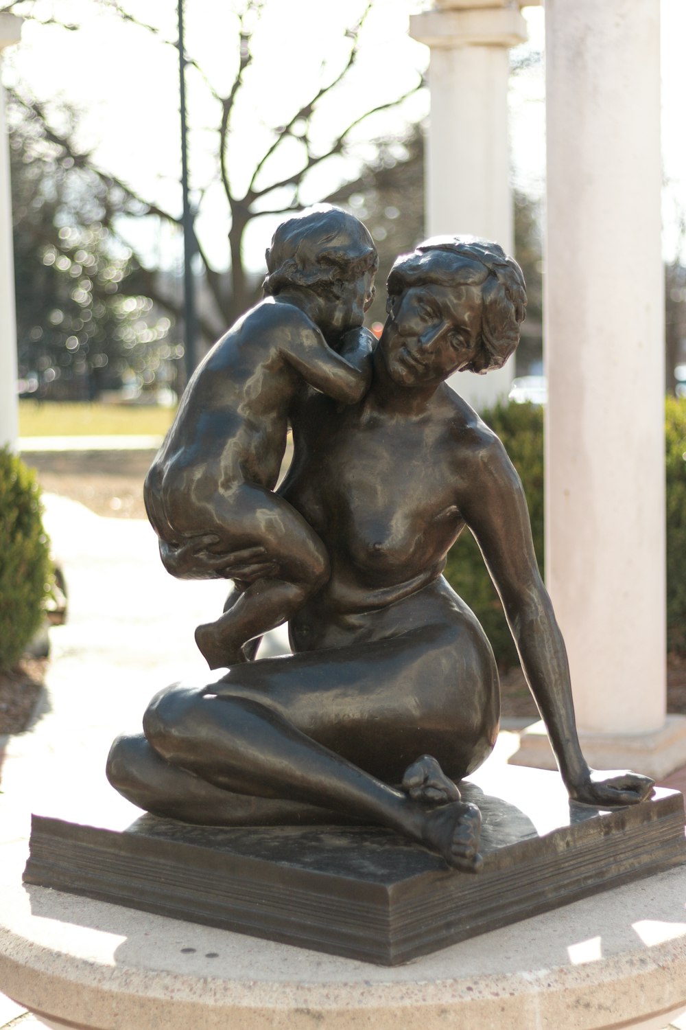 a bronze statue of a woman holding a child