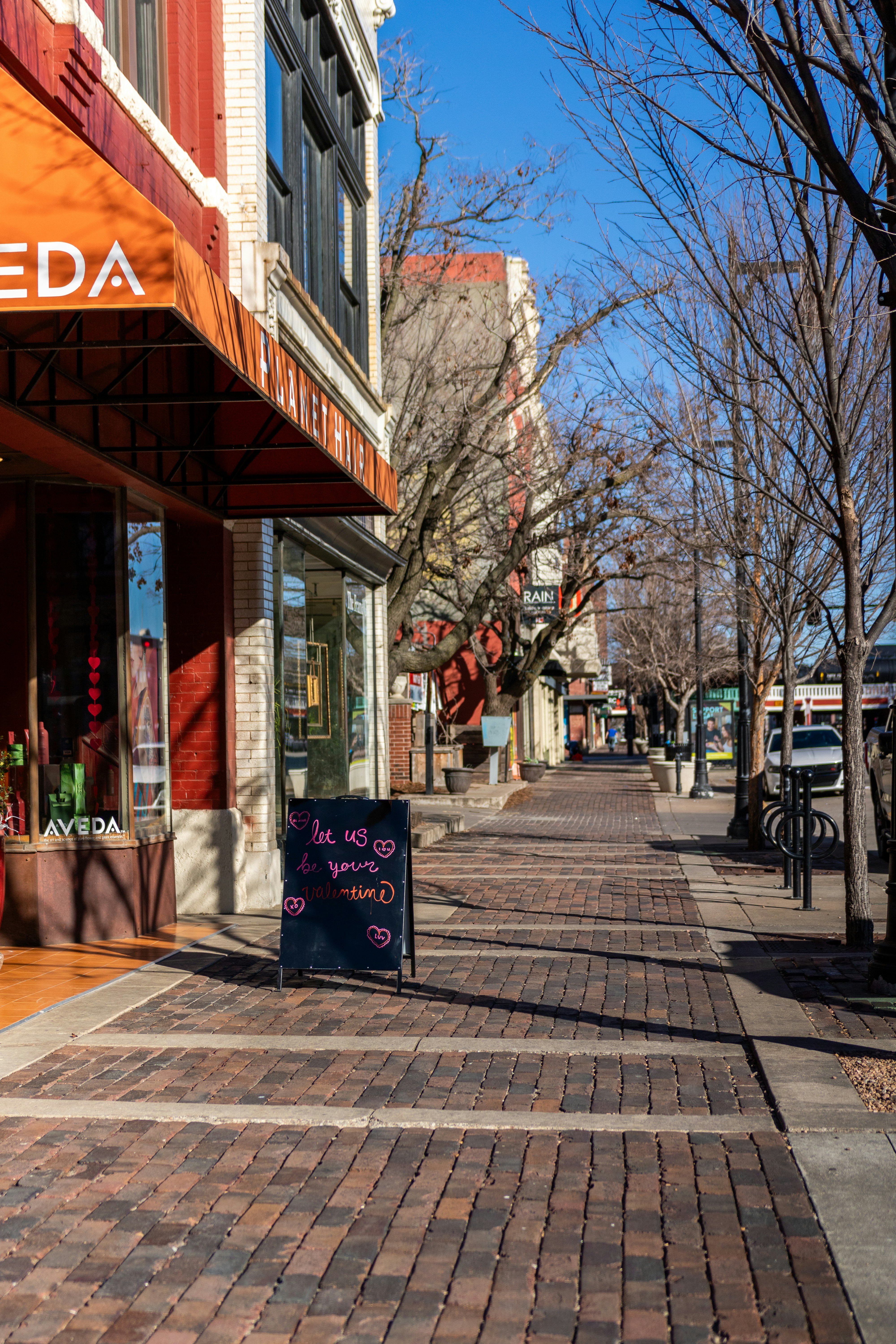 a brick sidewalk with a sign on the side of it