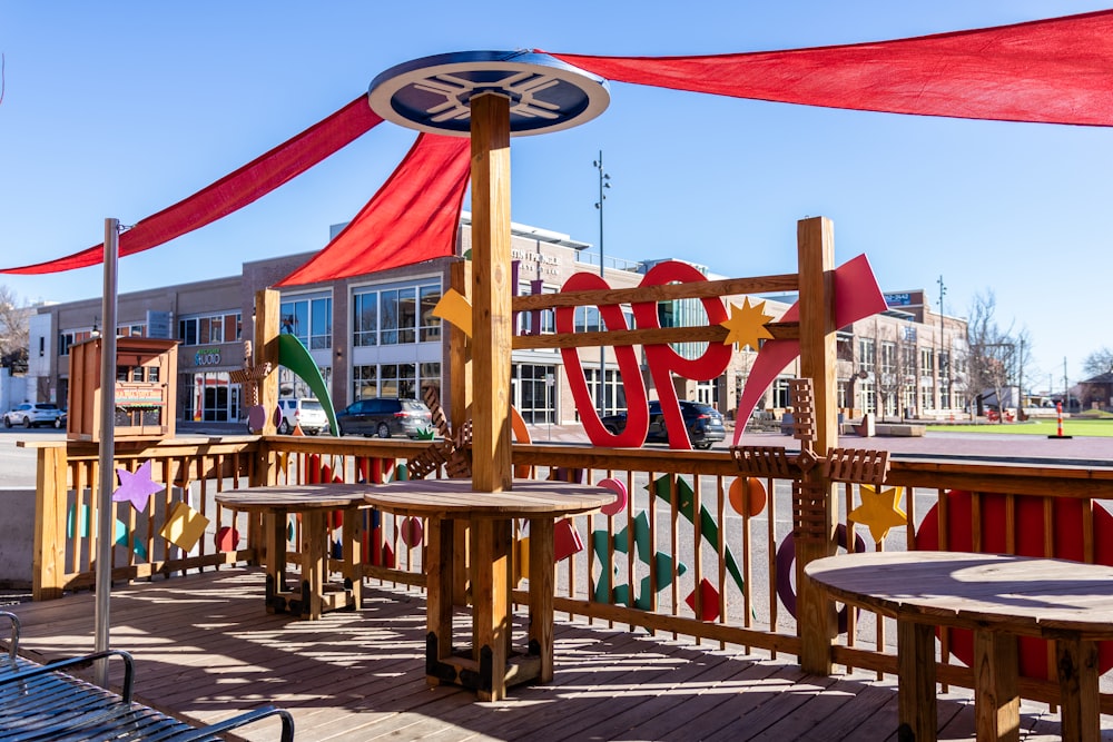 une terrasse en bois avec des bancs et des tables dessus