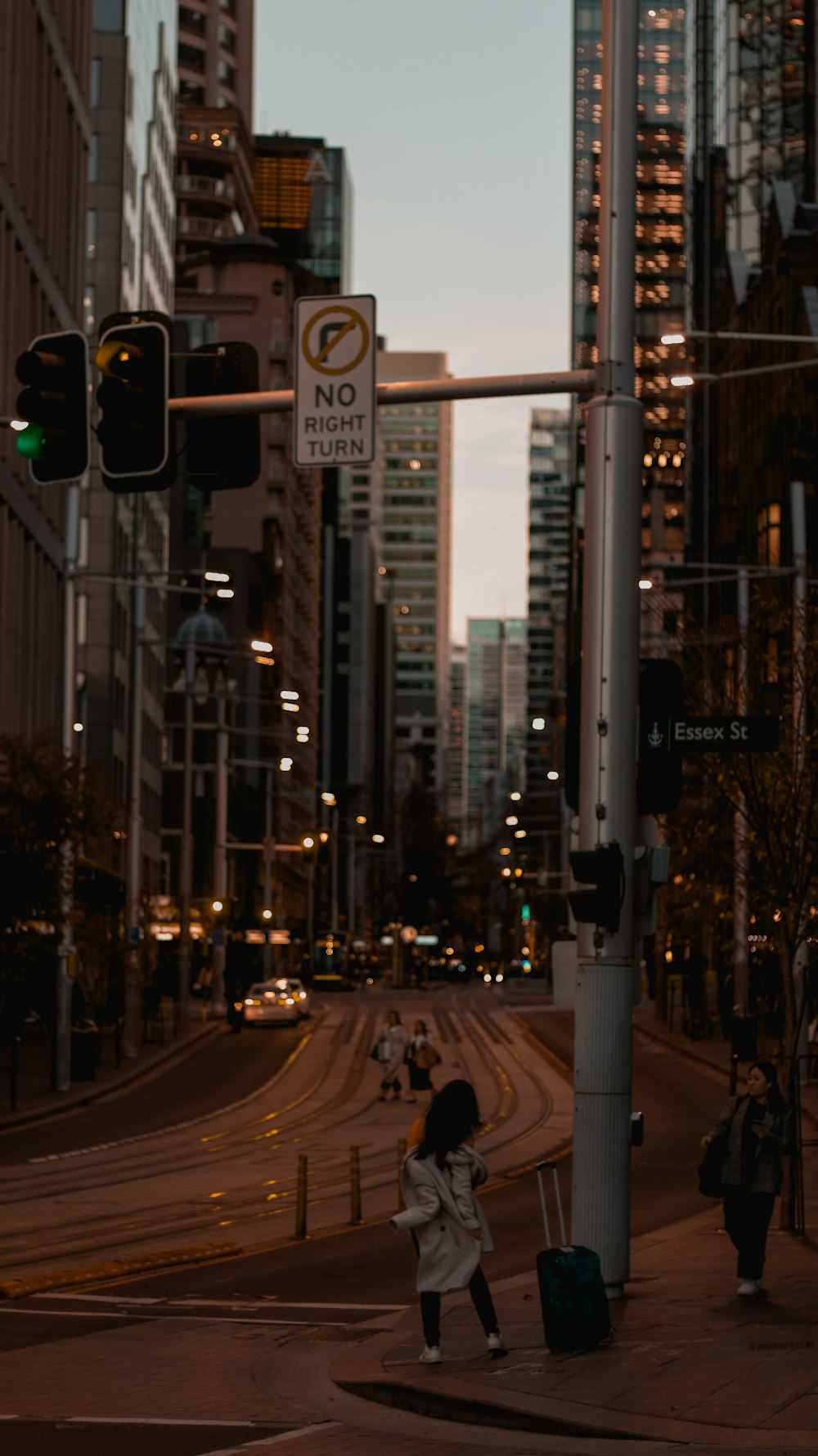 a woman crossing the street in a city at night