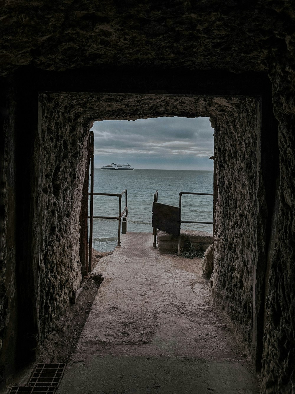 a stone tunnel with a bench in the middle of it