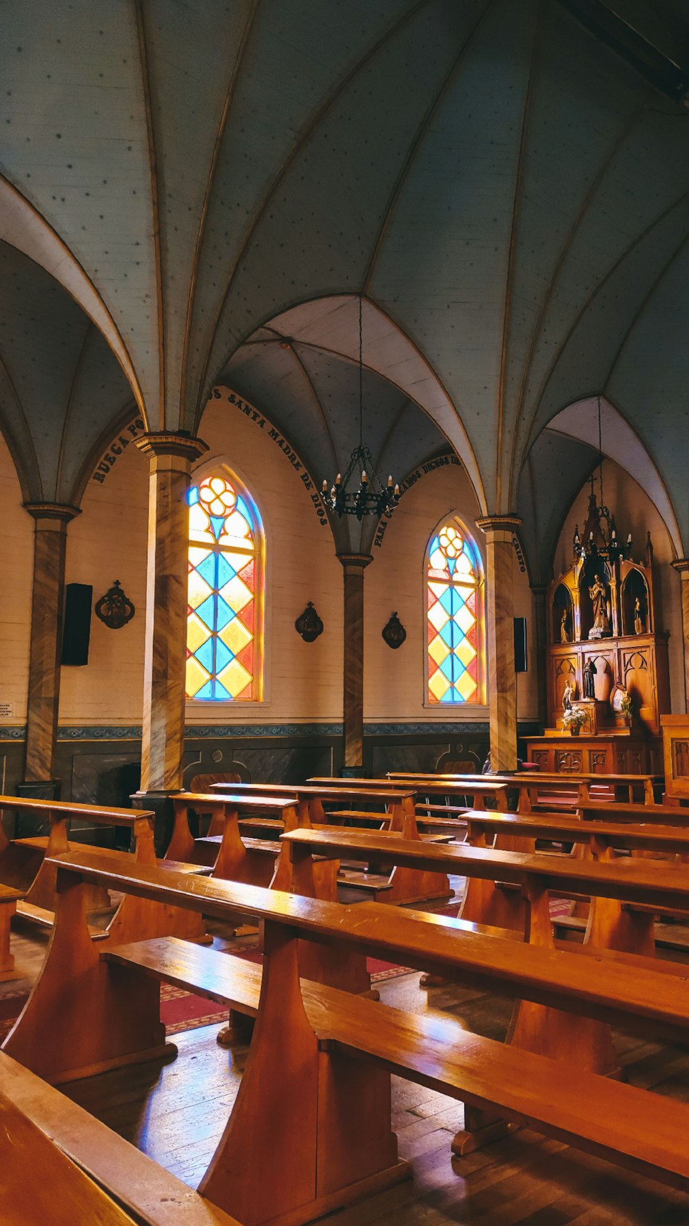 a church with stained glass windows and wooden pews