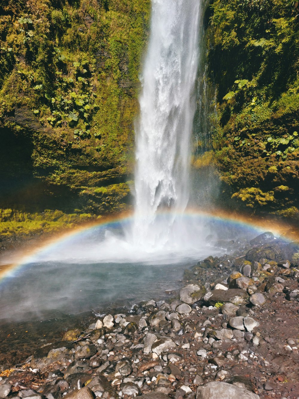 a waterfall with a rainbow in the middle of it