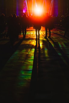 a group of people walking down a street at night
