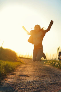a person jumping in the air on a dirt road