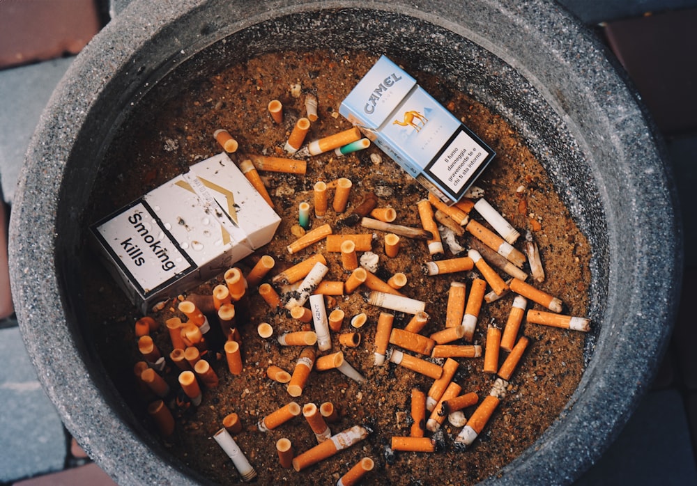 an ashtray full of cigarettes and cigarettes in a pot