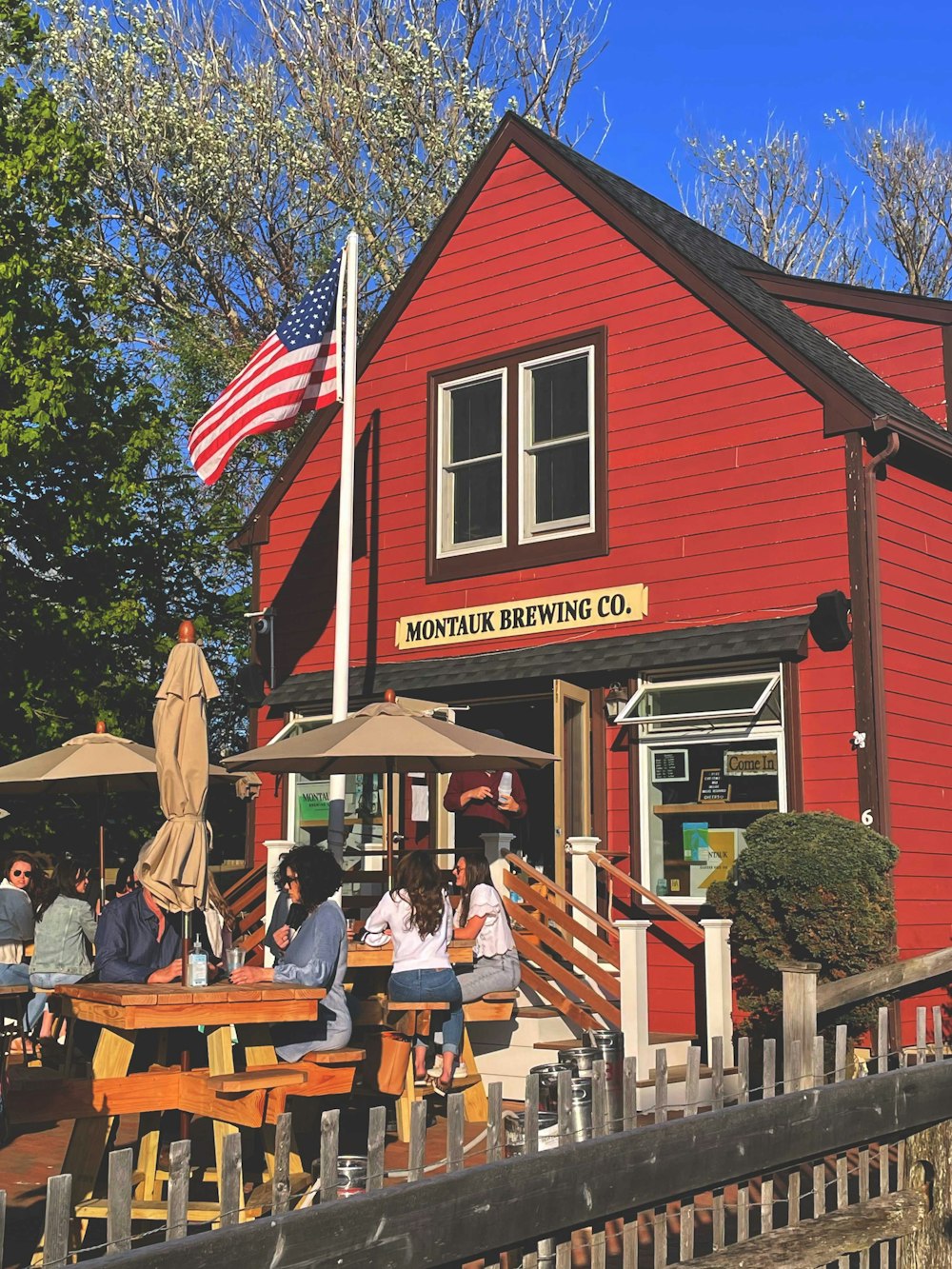 a group of people sitting outside of a red building