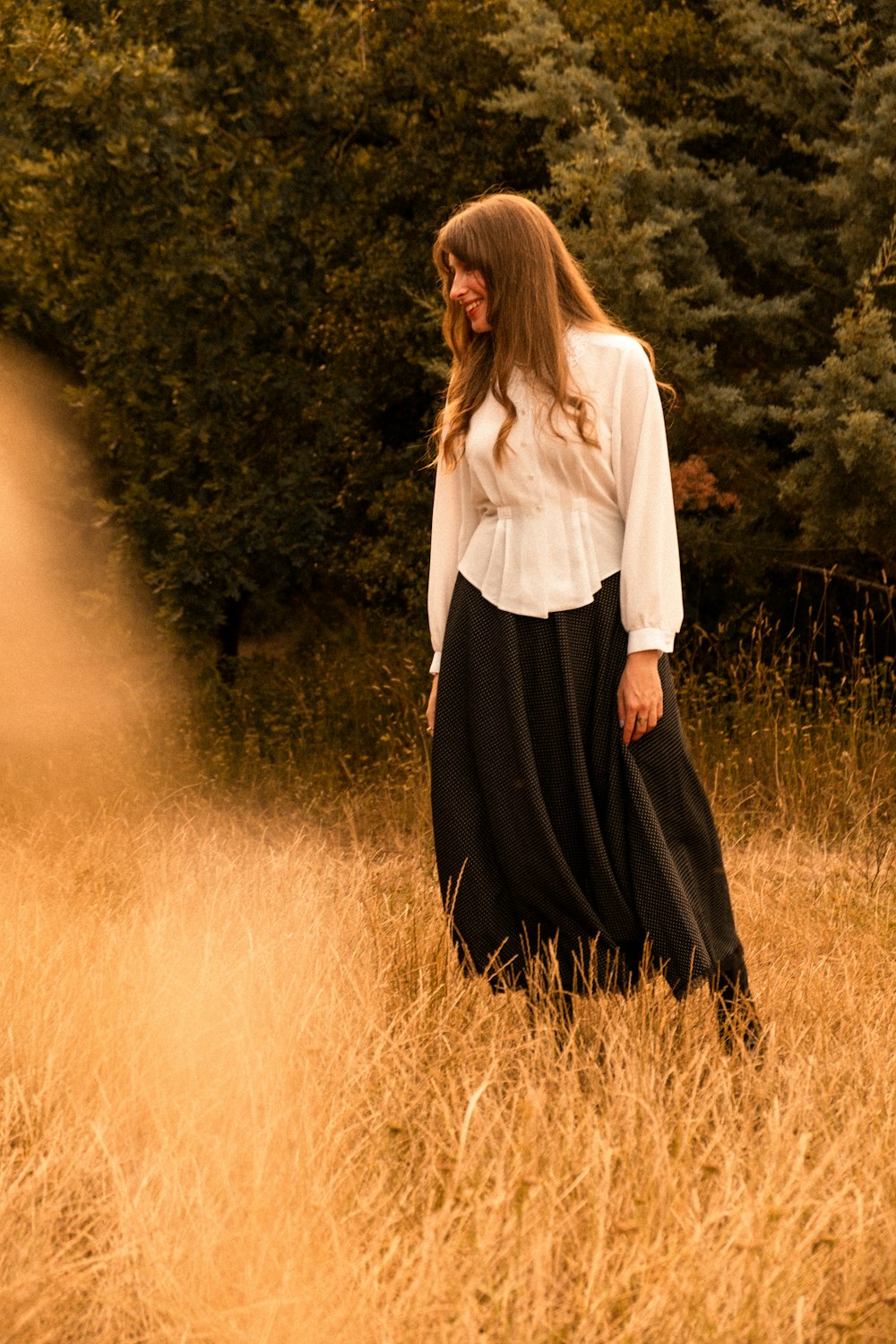 a woman standing in a field of tall grass