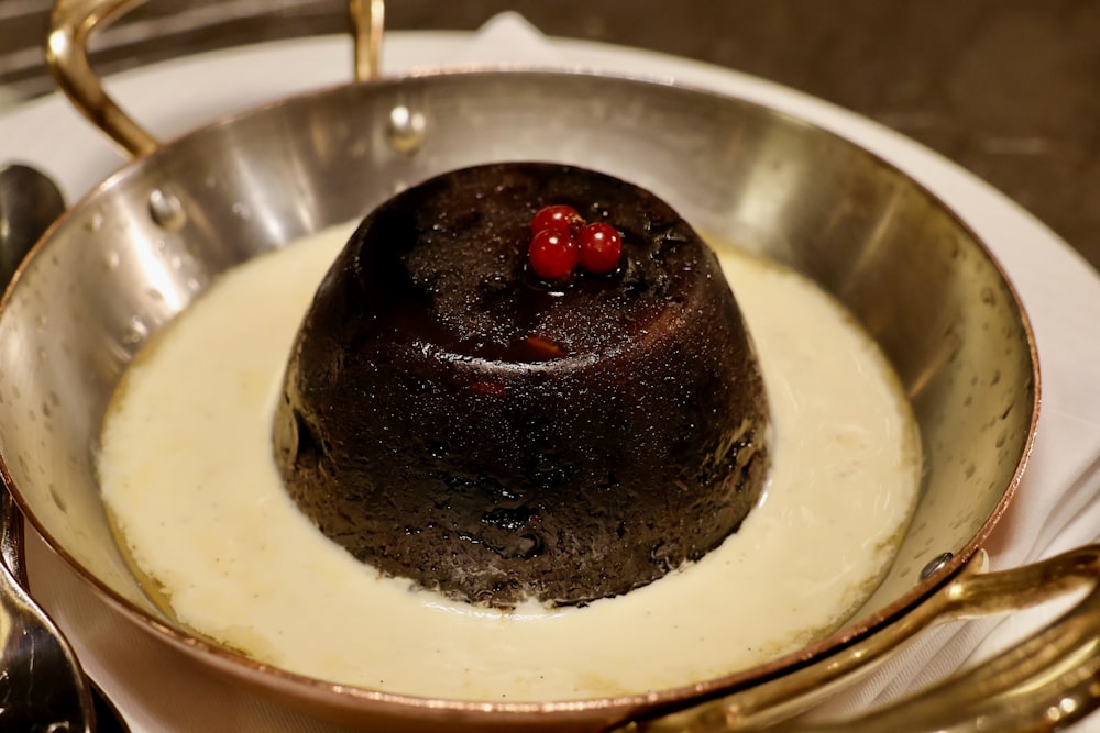 uma sobremesa de chocolate em uma panela de prata em uma mesa