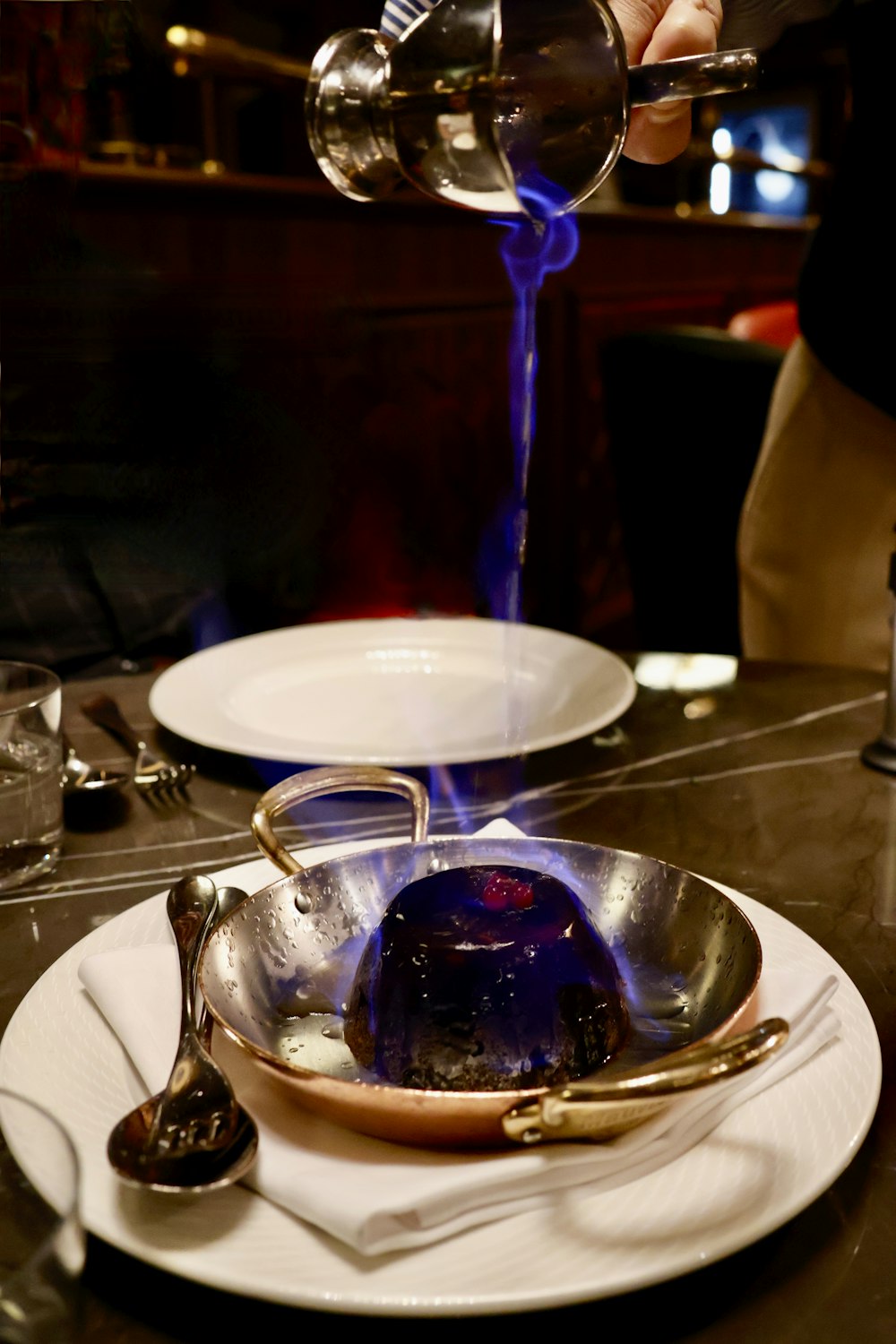 une personne versant un liquide bleu dans un bol sur une assiette