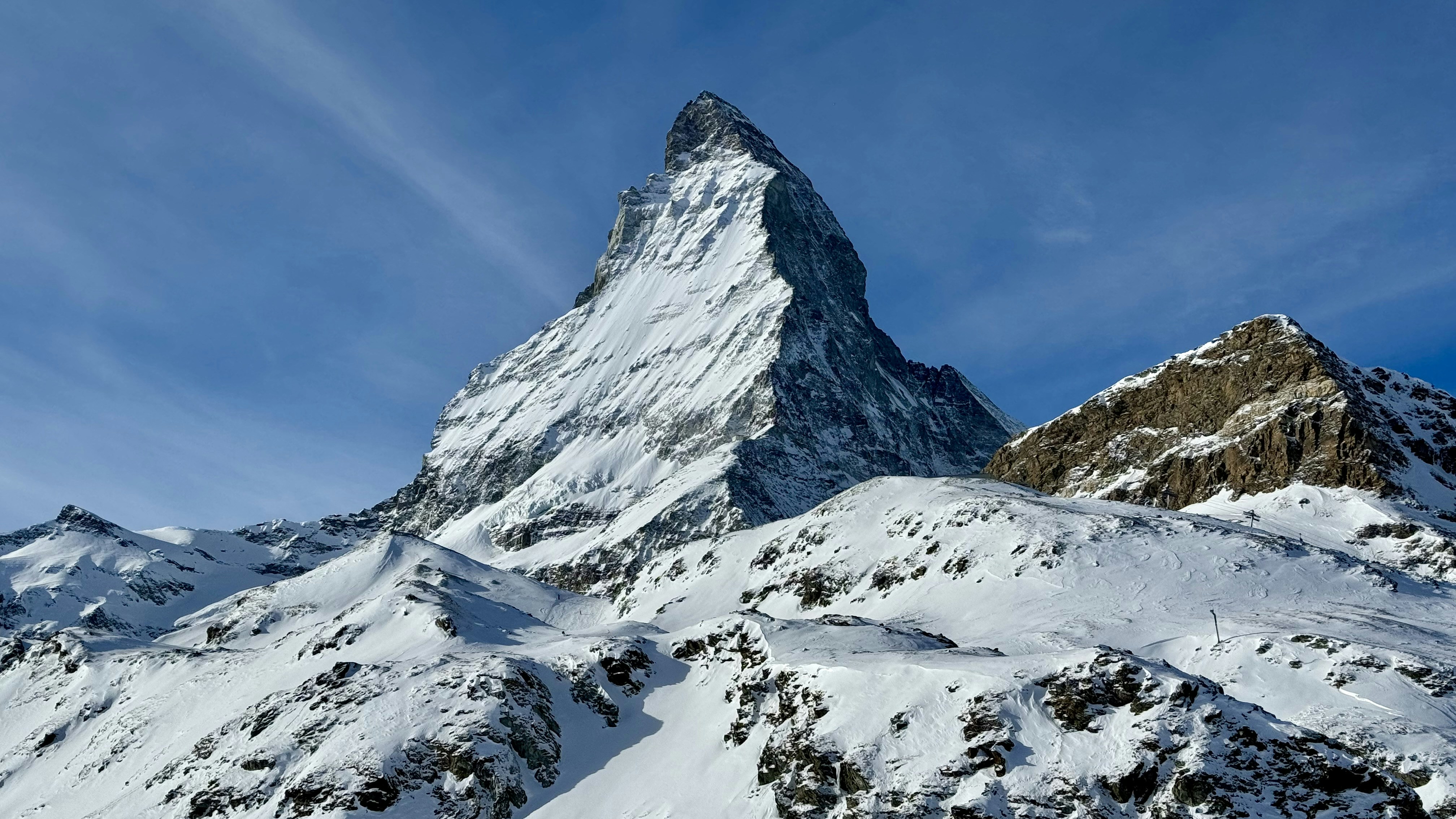una montaña cubierta de nieve con un cielo azul en el fondo