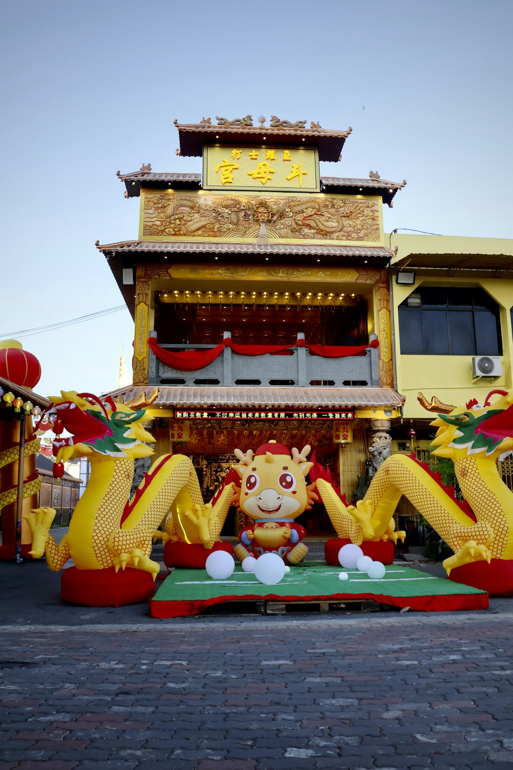 une grande statue de dragon jaune devant un bâtiment