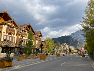 a street lined with wooden buildings with mountains in the background