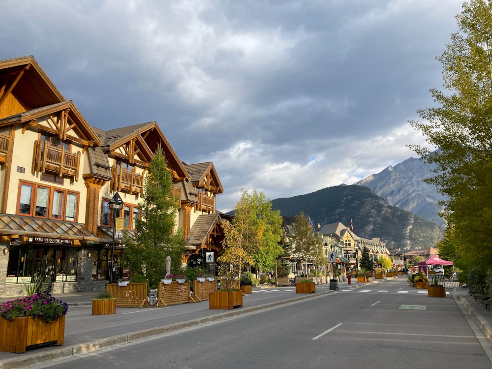 a street lined with wooden buildings with mountains in the background