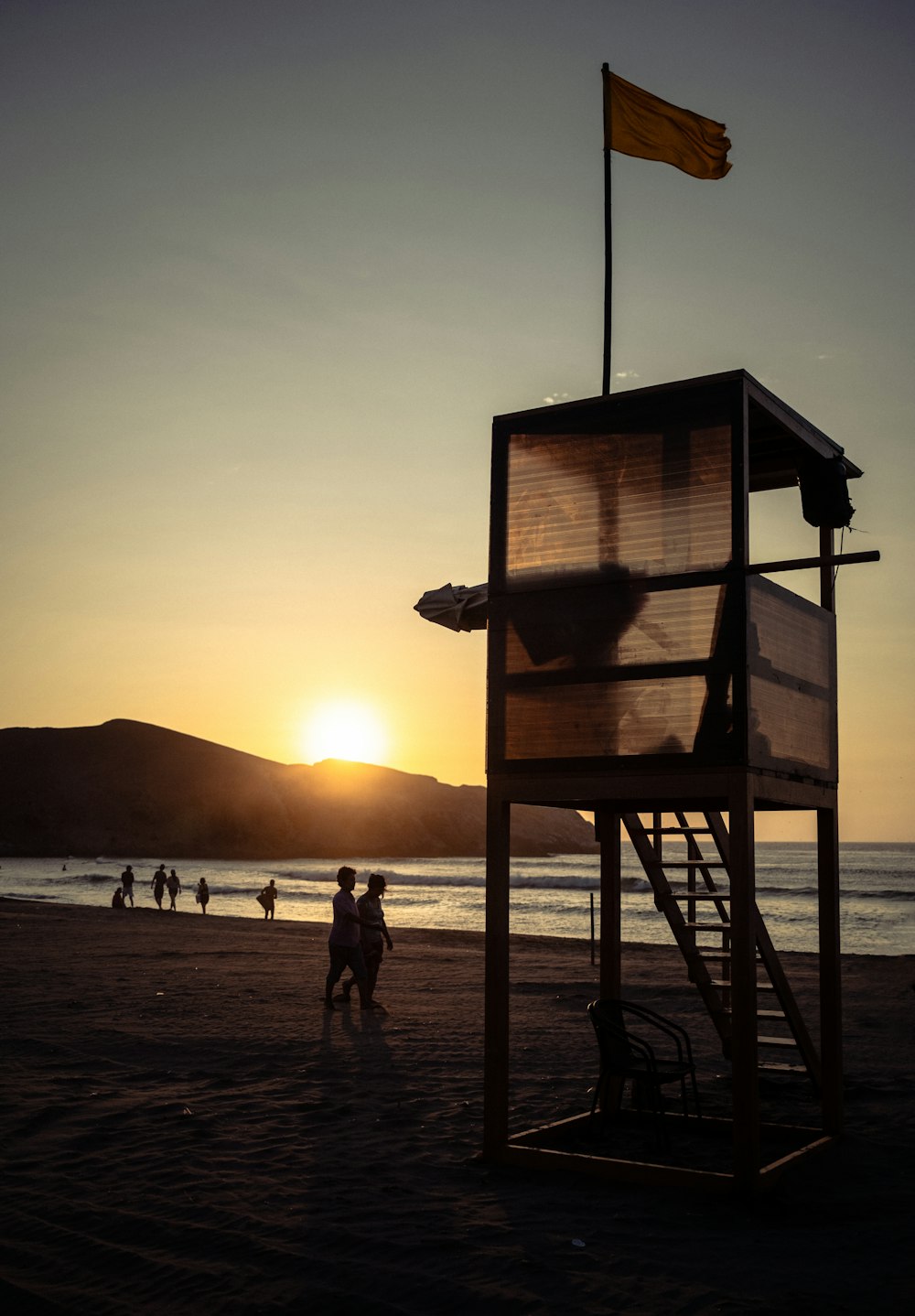 a lifeguard tower on a beach at sunset