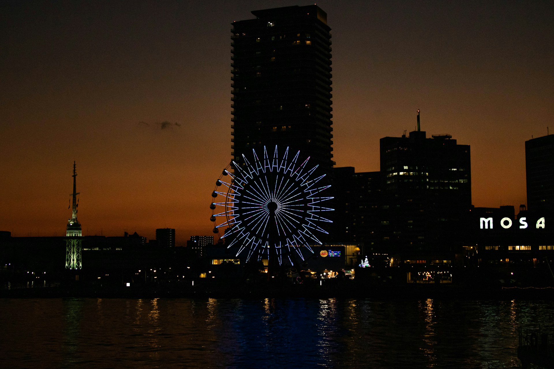 a ferris wheel in the middle of a city at night