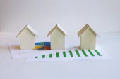three small houses sitting on top of a piece of paper