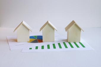 three small houses sitting on top of a piece of paper