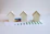 three small houses sitting on top of a piece of paper